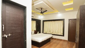A bedroom with a bed, a ceiling fan, and a window with curtains.