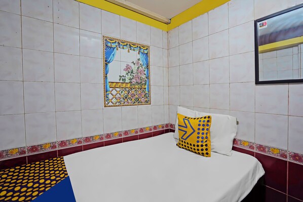 A hotel room with a bed, a window with a decorative frame, and a wall with a floral border. - OYO Life 92651 Meir E-homestay Syariah (Surabaya)