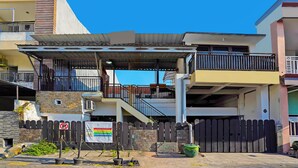 A two-story building with a covered outdoor area, a gated entrance, and a visible staircase leading to the upper floor. - OYO Life 92651 Meir E-homestay Syariah (Surabaya)