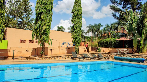 Una piscina con sillas de descanso y una zona de juegos.