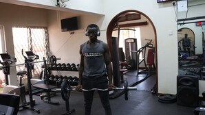 Un gimnasio con varios equipos de ejercicio, como mancuernas, una prensa de banca y una estructura para sentadillas.