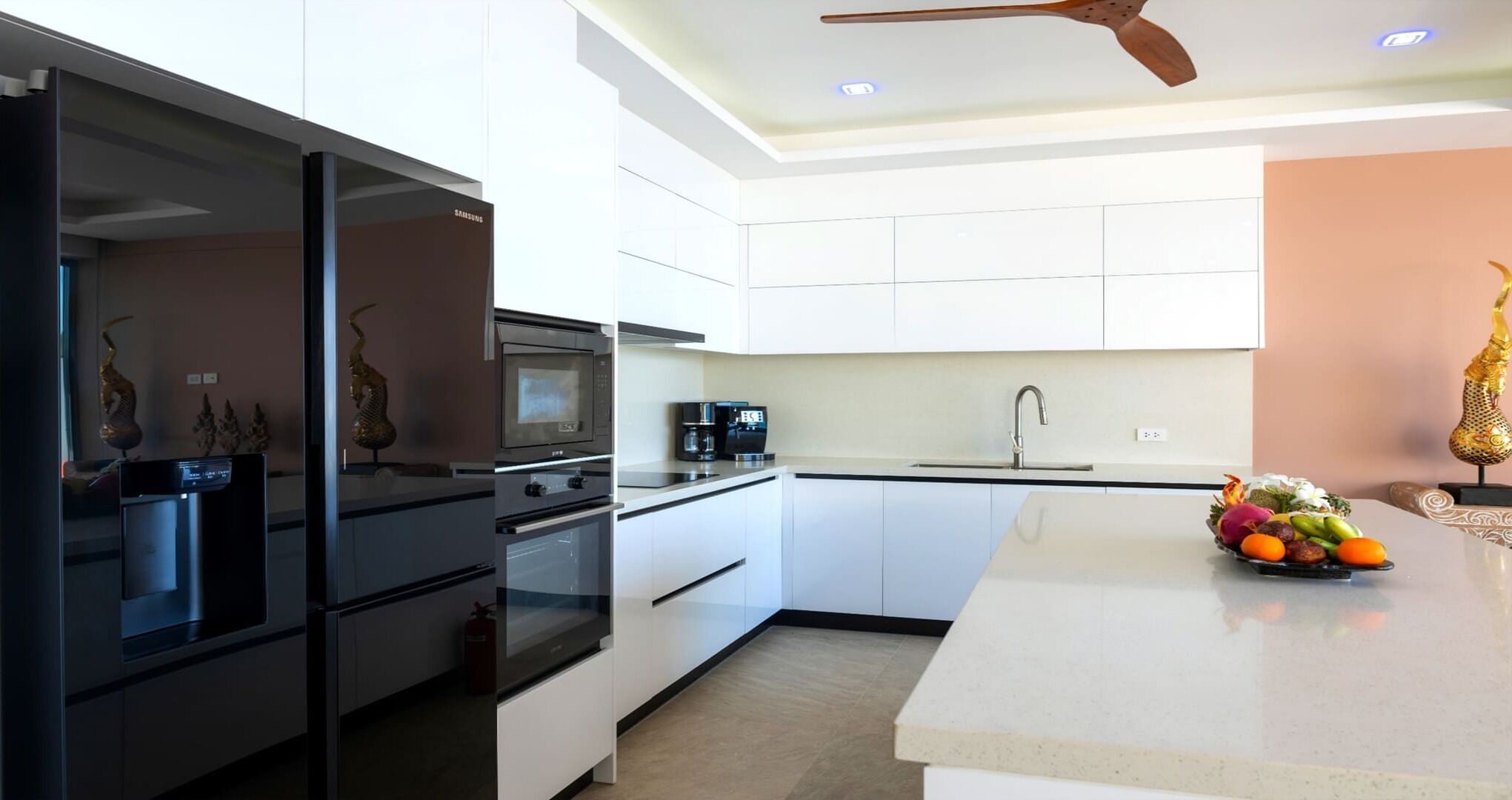 A modern kitchen with white cabinets, a black refrigerator, a microwave, an oven, and a coffee maker.