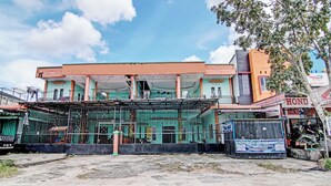 A building with a covered entrance and a fenced area in front. - Hotel O Penginapan Syafira Near Perumahan Mustamindo Permai 1 (Pekanbaru)