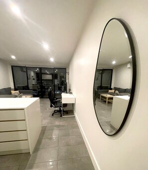 Een modern interieur met een grote spiegel, een bureau en een bank.