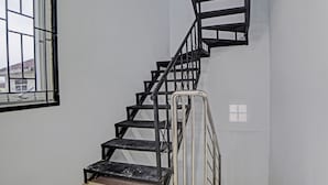 Un escalier avec des rampes en métal et une fenêtre avec des barreaux.