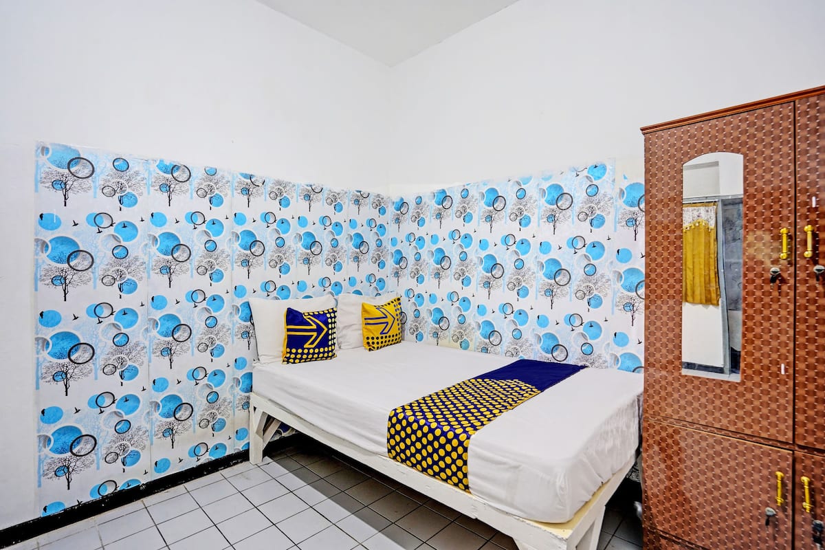 Une chambre à coucher avec un lit, des oreillers et une armoire.