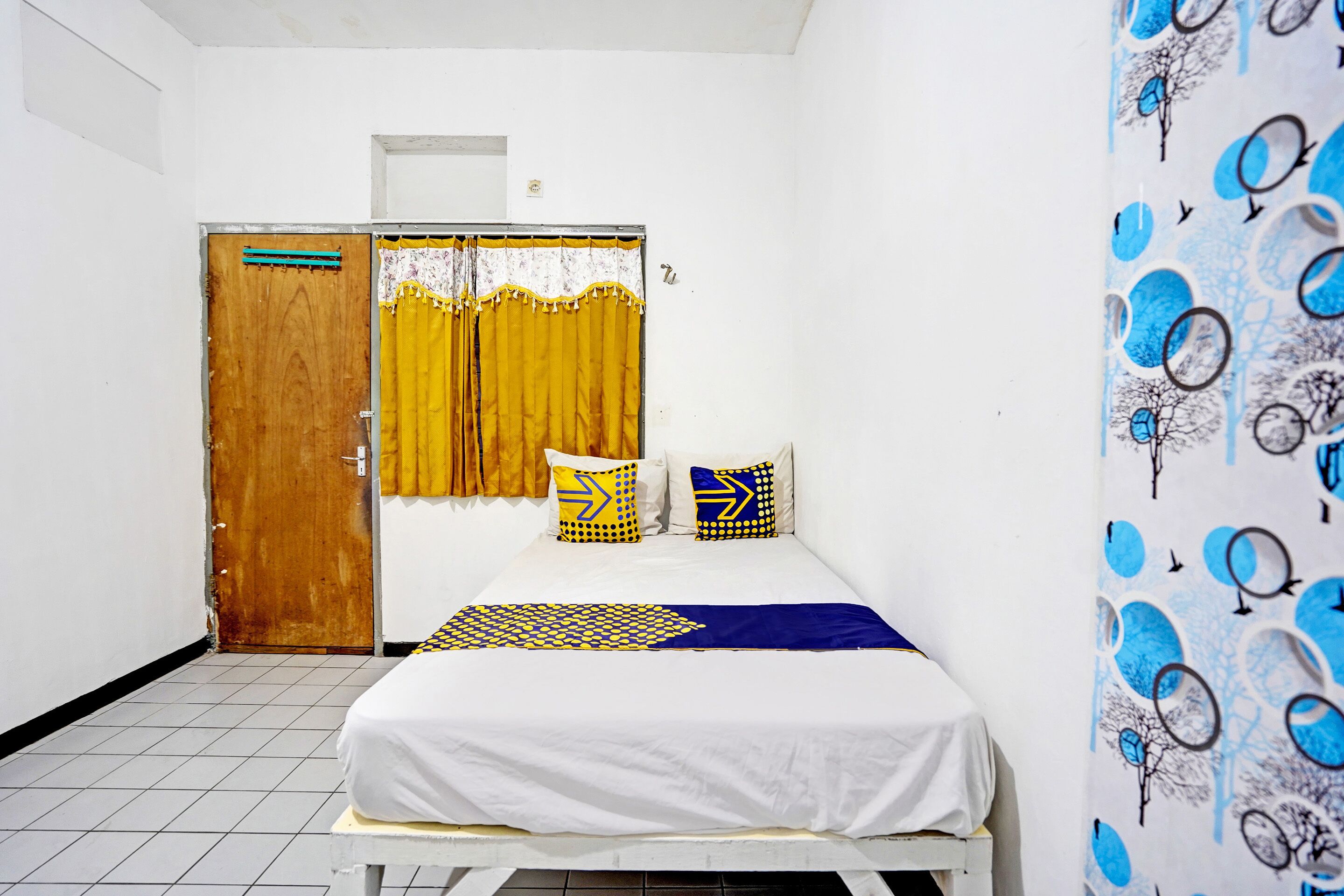 A room with a bed, a door, and a curtain.