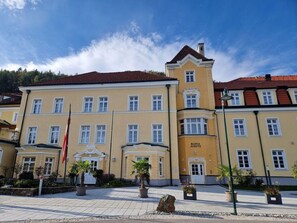 A yellow building with a red roof, multiple windows, and a sign that reads "Maria Schutz". - Kirchenwirt Maria Schutz (Schottwien)