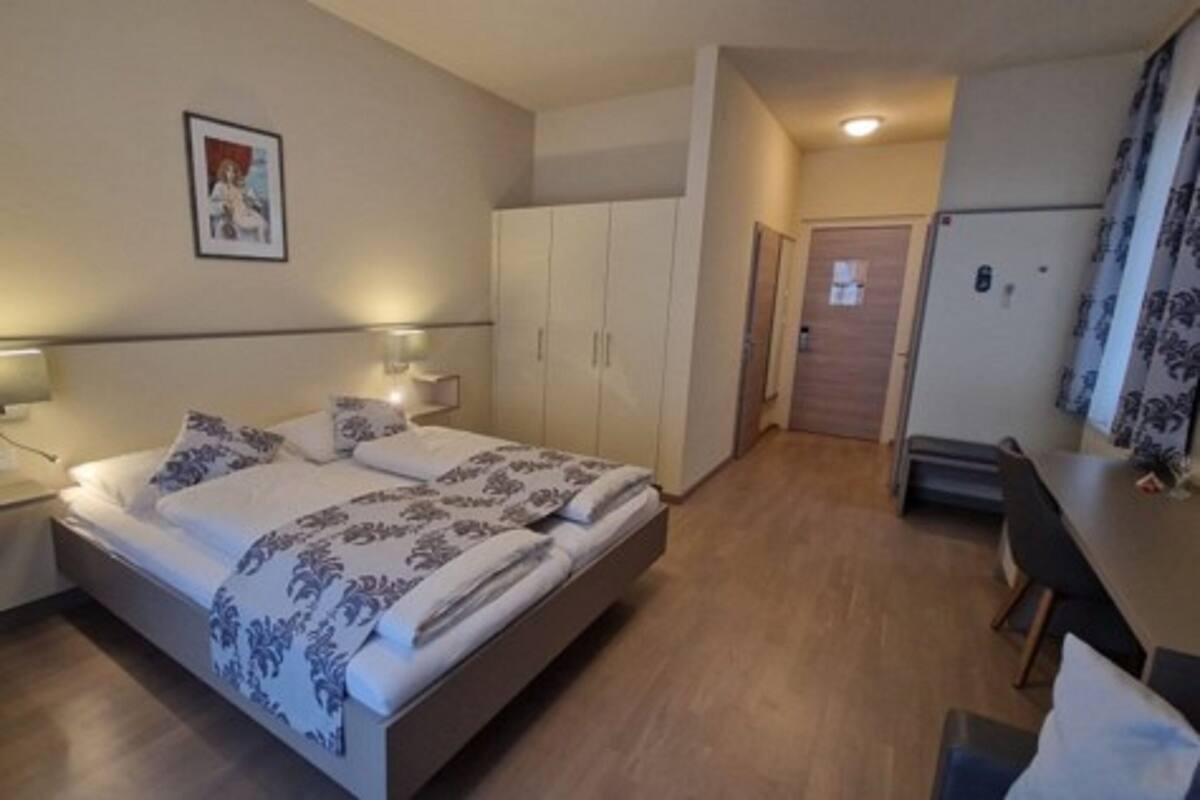 Un dormitorio con cama, mesita de noche y armario.
