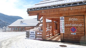 Ein Holzgebäude mit einem Schild, das einen Kinderspielbereich kennzeichnet.