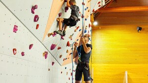 Ein Kletterzentrum mit gepolsterten Wänden und Klettergriffen.