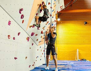 Ein Kletterzentrum mit gepolsterten Wänden und Klettergriffen.