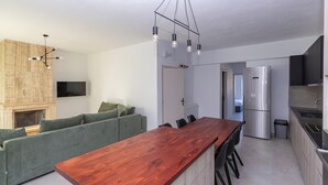 A modern kitchen with a wooden island, built-in appliances, and a green sofa.