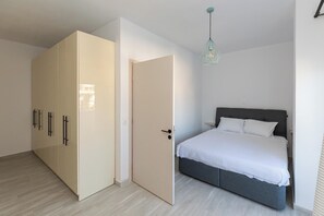 Un dormitorio con cama, armario y puerta.