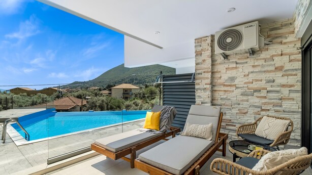 A rooftop terrace with a swimming pool, lounge chairs, and a view of the surrounding landscape. - Studio Apartment 'Oceanida Terpsis Lyxury Suite' with Sea View, Wi-Fi and Air Conditioning (Lefkada)