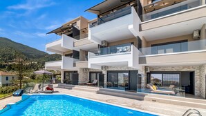 A modern multi-story building with a swimming pool, balconies, and a view of the surrounding landscape. - Studio Apartment 'Oceanida Thalia Lyxury Suite' with Sea View, Wi-Fi and Air Conditioning (Lefkada)