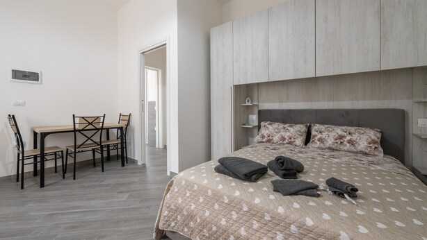 A bedroom with a bed, a bedside table, a chair, and a desk. - Holiday Home 'Casa Manu' with Private Terrace, Wi-Fi and Air Conditioning (Assemini)