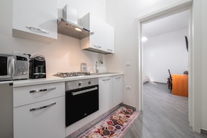 A modern kitchen with a microwave, coffee maker, and oven.