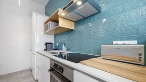 Une cuisine moderne dotée d’une cuisinière intégrée, d’un évier et d’un plan de travail en bois.