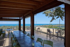 Un área de comedor al aire libre con vistas al mar y al pueblo.