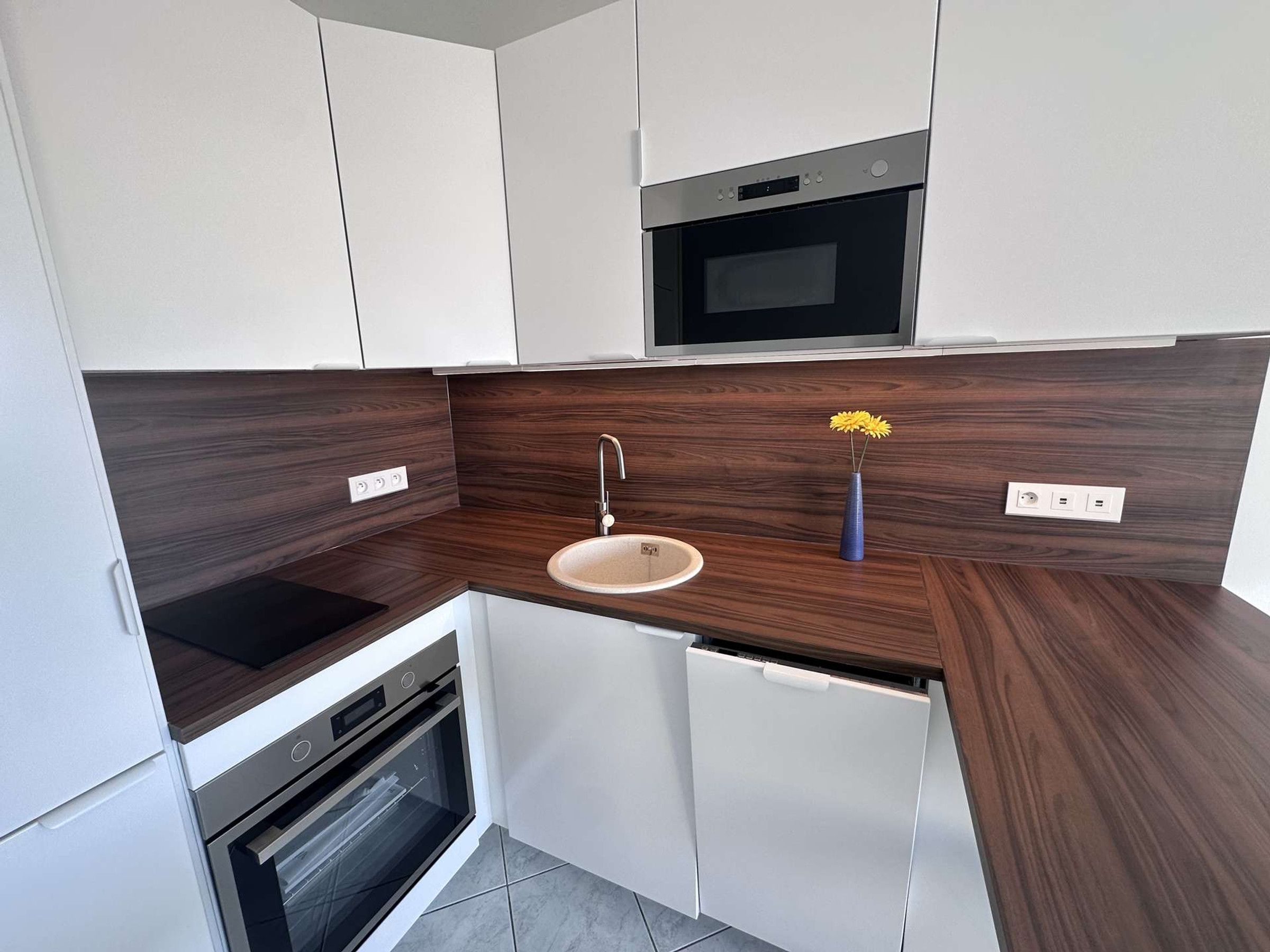 A compact kitchen with a built-in microwave, a sink, and a dishwasher.