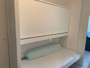A bunk bed with a mattress and a pillow. - Sea view studio-cabin 50m from beach, private parking (Port Camargue)