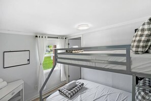 A bunk bed room with a white desk and a window with curtains. - Qt Cottage on Dunn's Creek, Fire Pit, Kayaks (Satsuma)