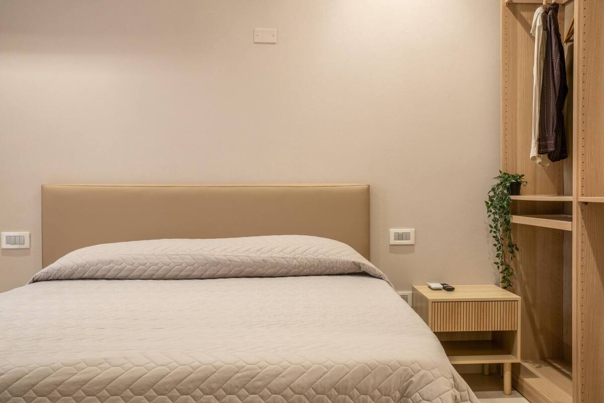 Ein Schlafzimmer mit Bett, Nachttisch, Schrank und Kleiderschrank.