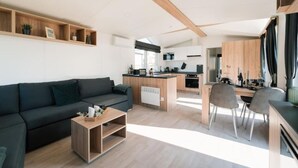 A modern living space with a sofa, coffee table, and dining area.