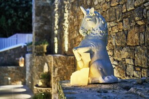 A stone statue of a horse holding a block of stone, set against a stone wall. - Aqua Mykonos Suites - Adults Only (Mykonos)