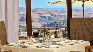 Mesa dispuesta para comer con vistas a un paisaje montañoso.