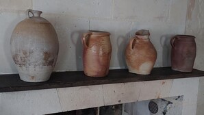 A row of five ceramic pots of varying sizes on a shelf against a plain wall. - Charming cottage with garden near castles, WiFi, parking included (Benais)