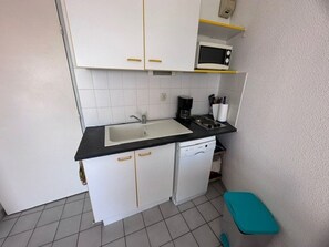 A compact kitchen with a sink, microwave, and coffee maker. - 2-room apartment with terrace and parking in Le Grau-du-Roi for 4 people (Le Grau-du-Roi)