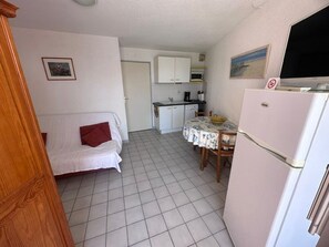 A compact living space with a kitchenette, a dining area, and a sofa. - 2-room apartment with terrace and parking in Le Grau-du-Roi for 4 people (Le Grau-du-Roi)