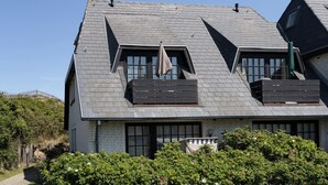 A house with a steeply pitched roof, dormer windows, and a visible chimney.