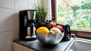 A kitchen counter with a coffee maker, a bowl of fruit, and a toaster. - Hochwertiges 1-zi-app für 2+1 Pers. am See, Wlan, Terrasse, Elektr. Kamin (Mirow)