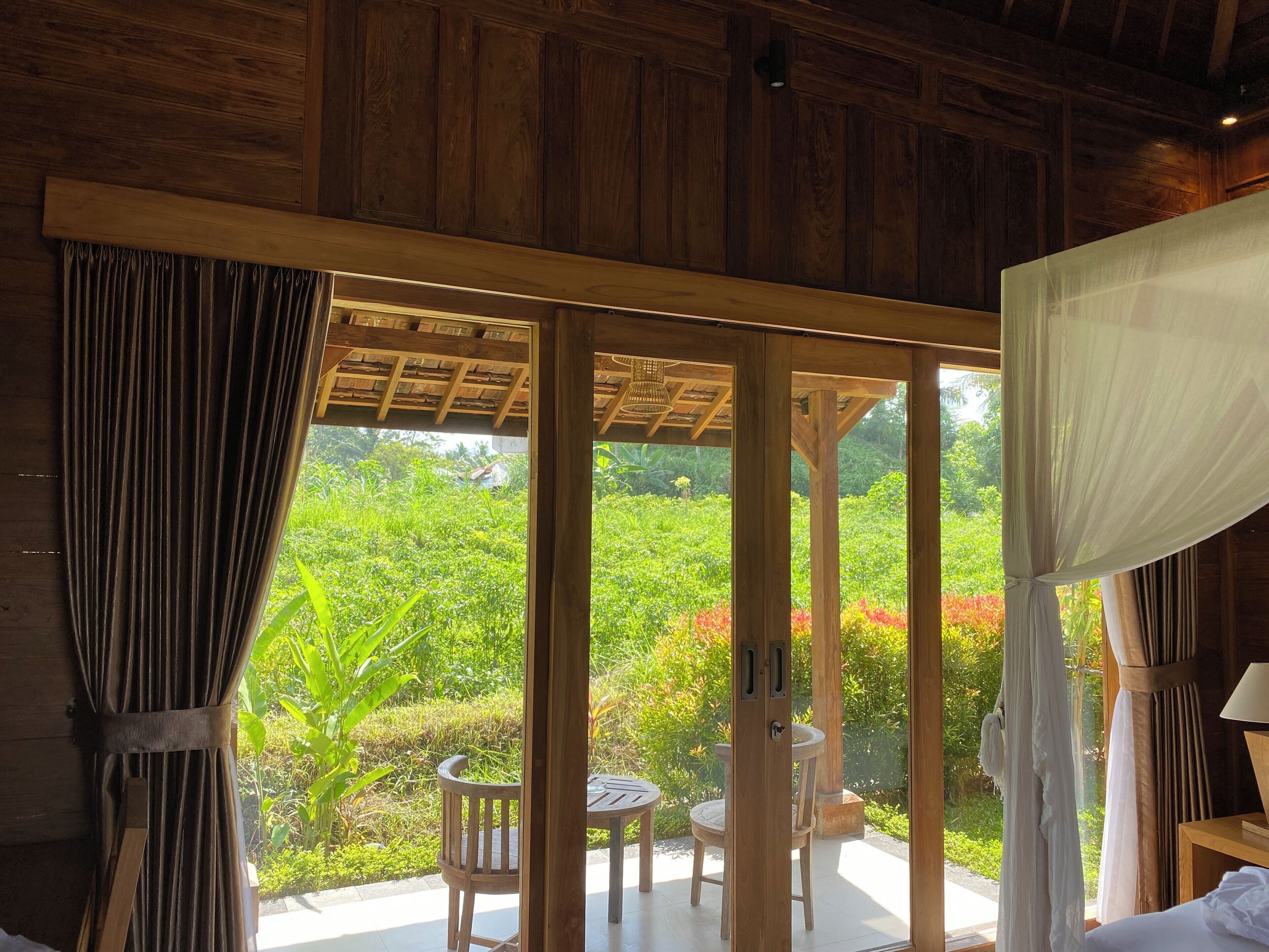 A wooden room with a sliding glass door leading to an outdoor patio.