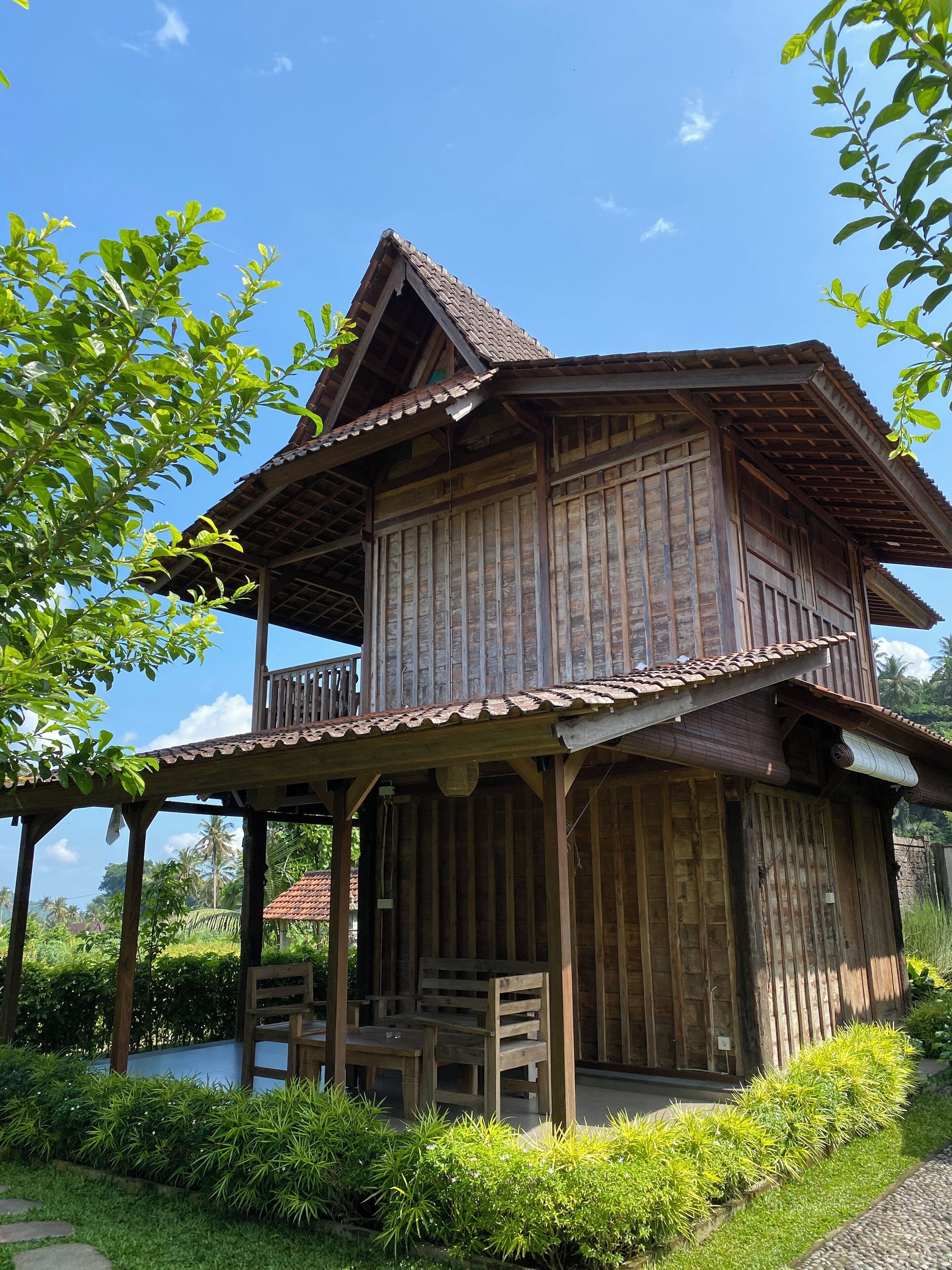 Una casa de madera con balcón y porche cubierto.