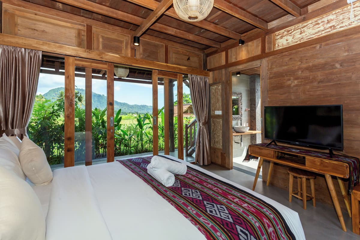 Une chambre avec un grand lit, une télévision et une vue sur les montagnes.