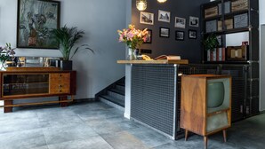 Un interior moderno con un mueble de madera, un televisor antiguo y un estante con cajas de almacenamiento.