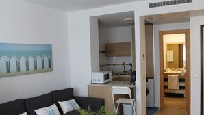 A modern apartment with a living area, kitchenette, and a small bathroom. - Paseo Maritimo (Málaga)