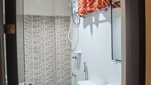 Un baño pequeño con inodoro, lavamanos y ducha.
