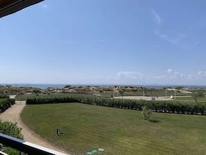 A view of a grassy area with a path leading to a gate, a clear sky, and distant hills. - Cozy apartment for 4, near beach and shops in Port Camargue, private parking (Port Camargue)