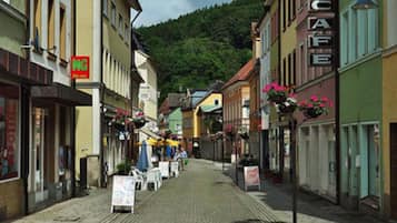 Eine Kopfsteinpflasterstraße gesäumt von bunten Gebäuden, darunter ein Café.