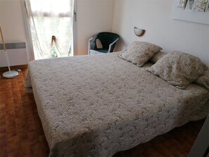 A bedroom with a large bed, a chair, and a floor lamp. - Direct beach access, 3 rooms, 6 beds, private parking (Port Camargue)