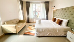 Une chambre d’hôtel moderne, dotée d’un grand lit, d’un canapé et offrant une vue sur l’extérieur.