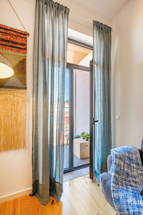 Relax in a welcoming space with a comfortable sofa, sliding glass door to an outdoor area, and a textured wall hanging.