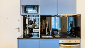 A compact kitchen with a built-in oven, a stove, and a sink. - Balcony City Views (Porto)