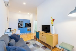 Cozy living space with a comfortable sofa, flat-screen TV, and kitchenette.
