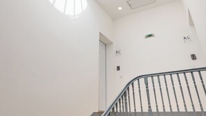 A modern interior with a spiral staircase, a circular skylight, and a minimalist design. - Balcony City Views (Porto)